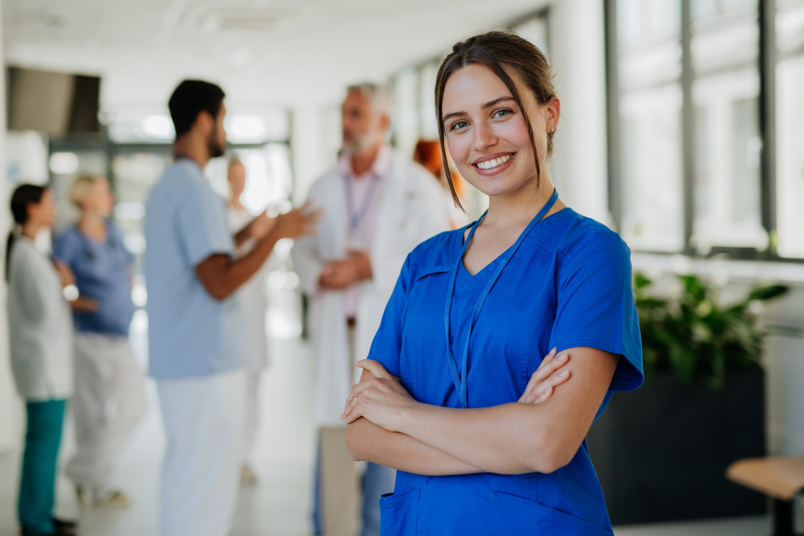 Portrait of young woman nurse at hospital corridor.